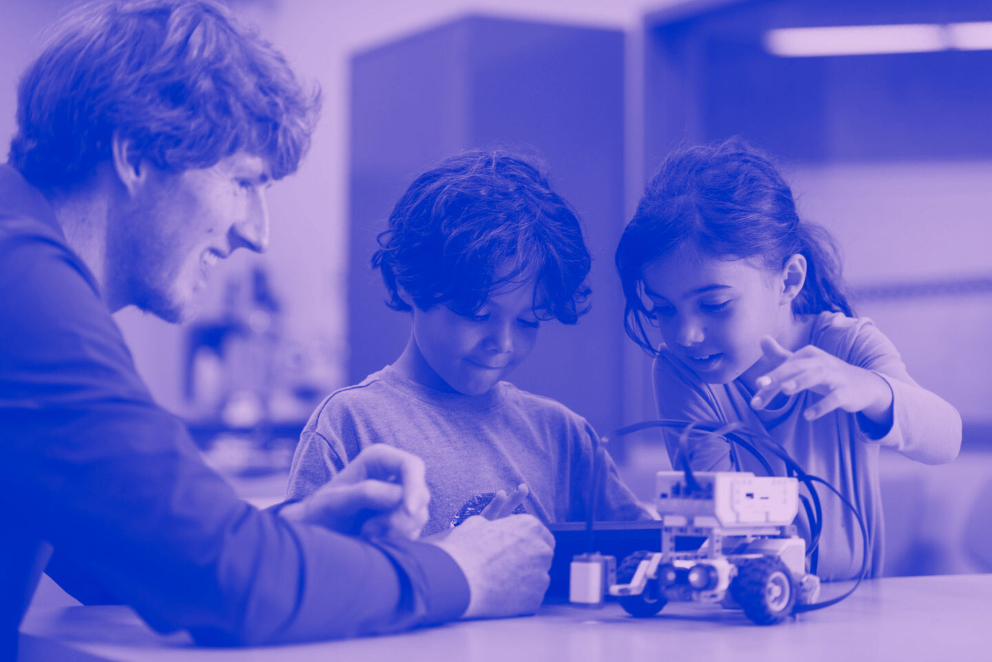 Two children and a staff member are working together during a science activity.