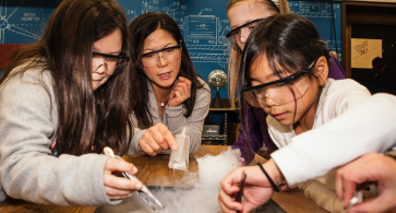 Students wearing safety glasses working together on a science experiment