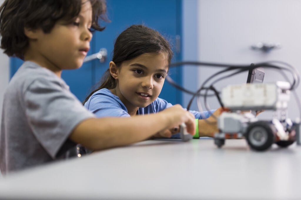 Two children are examining a model vehicle
