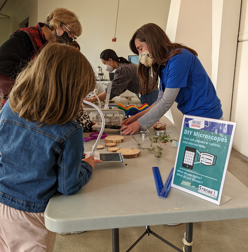 Students and an adult participate in a Microscopes of Tomorrow activity